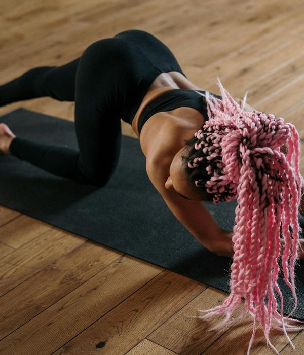Person practicing gentle yoga movements in a dark studio